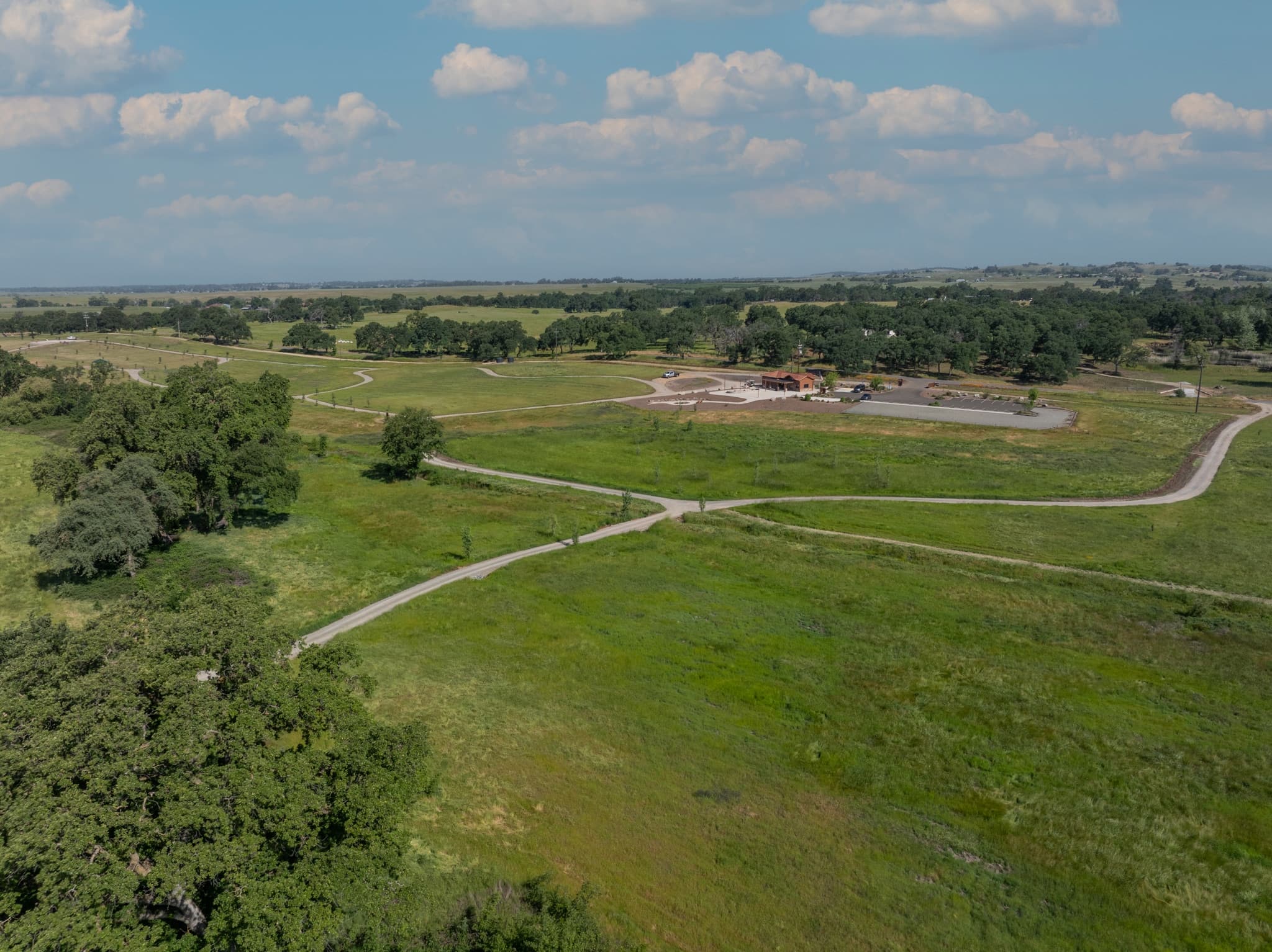 Aerial view of Morgan Oaks Eternal Preserve green burial cemetery in Lincoln, CA, with gravel trails winding through meadows and native oak woodland