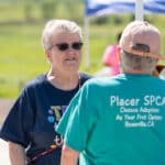 Two seniors chatting outdoors at community event