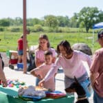 Family and dog shopping at outdoor community market