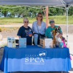 SPCA volunteers at outdoor booth with dog and flyers