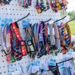 Assorted colorful handmade dog collars displayed on board