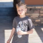 Young boy holding water bottle outdoors