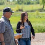 Woman and family walking outdoors, smiling with picnic basket