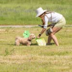 Woman and dog enjoying Easter egg hunt outdoors