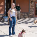 Woman speaking into microphone with dog on leash