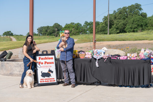 Couple with dogs at outdoor pet boutique booth