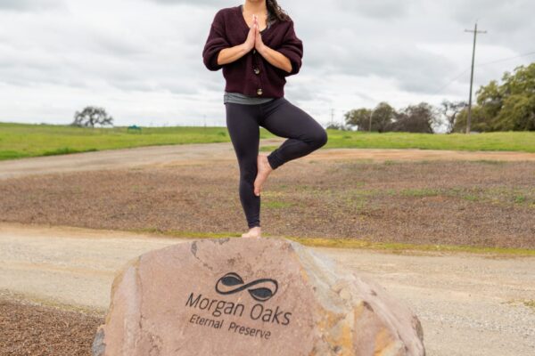 Woman practices yoga on Morgan Oaks rock outdoors
