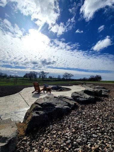 Sunlit patio with chairs overlooking expansive rural landscape