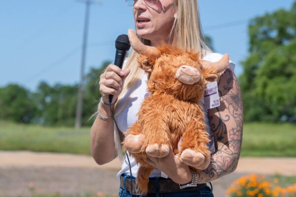 _A745293 Woman speaking outdoors holding stuffed animal